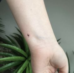 a person's wrist with a small tattoo on the left side of their arm