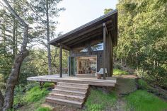 a small cabin in the woods with steps leading up to it