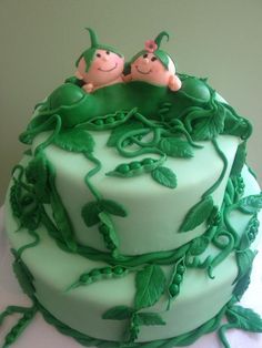 there is a cake with green frosting and two small figurines on top