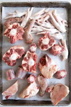 raw meats are laid out on a baking sheet and ready to be put into the oven