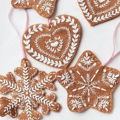 three heart shaped gingerbread cookies decorated with white frosting