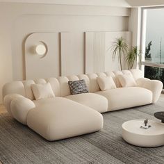 a large white couch sitting in a living room next to a window