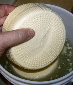 a hand is pressing the top of a pizza dough in a bowl