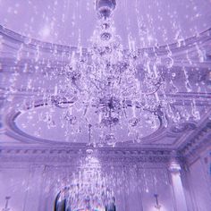 a chandelier hanging from the ceiling in a room with white walls and ceilings