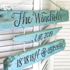 three wooden signs hanging from the side of a building