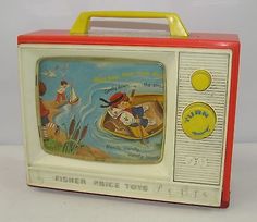 an old fashioned television sitting on top of a white table next to a yellow object