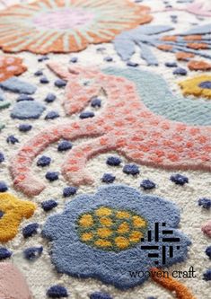 a close up view of a rug with flowers and birds on the ground in pastel colors