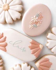 decorated cookies with the word love written on them and flowers in front of one cookie