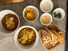 bowls of chili, tortilla chips and sour cream