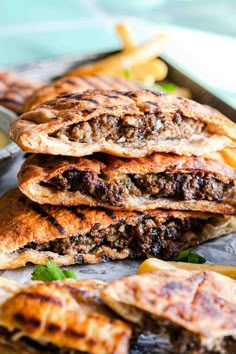 several pita breads stacked on top of each other with dipping sauce in the background