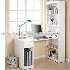 a white computer desk sitting under a window next to a book shelf with a laptop on it