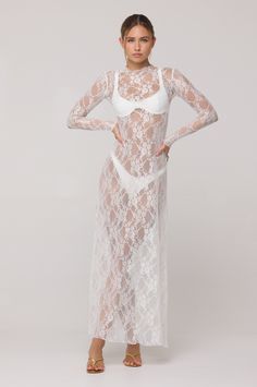 Discover elegance with the Lyon Lace Dress in White Lace. Crafted with a stunning white lace fabric and a high neck, this maxi dress. The sheer design adds an alluring touch, making it perfect for any vacation over our swimsuits. Elevate your style and embrace timeless beauty with this dress. This top is SHEER in our soft LACE fabric Maxi Length Lettuce Hem Neck and Wrist Detail Fabric: 95% Polyester 5% Spandex Model A is wearing a size XS Model A Measurements: Height 5'7, Waist: 25", Hips 32" B White Sheer Lace Dress, Sheer Lace Dress, White Lace Fabric, Transparent Dress, Lettuce Hem, Short Lace Dress, White Swimsuit, Lace Bodycon Dress, Pretty Dress