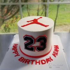 a birthday cake with the number 23 on it and an air jordan hat topper