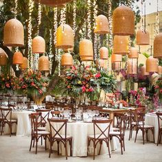 the tables are set with white linens and floral centerpieces hanging from the ceiling