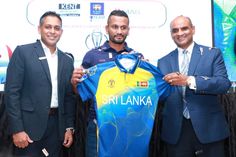 three men standing next to each other while holding up a soccer jersey with the name sri lanka on it