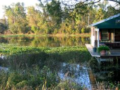 a small house sitting on top of a wooden dock next to a body of water