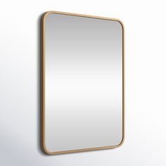 a mirror hanging on the wall next to a white wall with a light brown frame