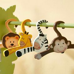 there are many wooden animals hanging from the clothesline rail in this nursery room with green walls