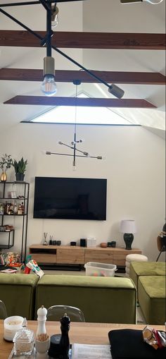 a living room filled with furniture and a flat screen tv mounted on the wall above it