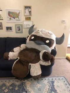 a large stuffed animal sitting on top of a blue couch