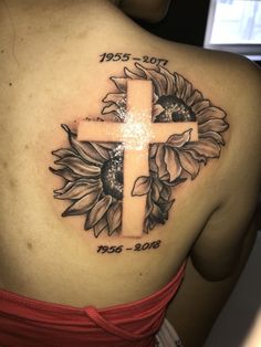 a woman with a cross and sunflower tattoo on her back