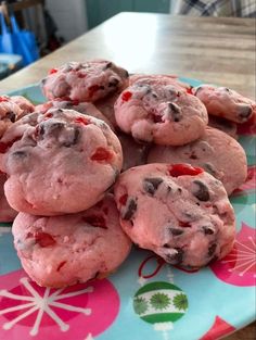 a close up of a plate of cookies on a table with pink icing and sprinkles