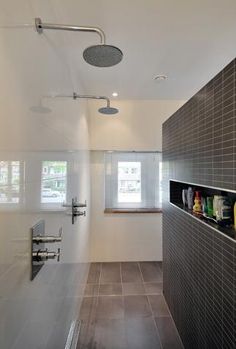 a bathroom with tiled walls and flooring next to a window in the middle of the room