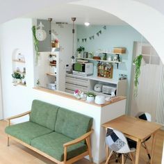 a living room filled with furniture next to a kitchen and dining area in front of a window