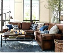 a living room filled with lots of furniture and decor on top of a blue rug