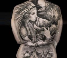 a woman with tattoos on her back holding a wolf