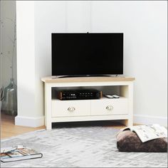 a flat screen tv sitting on top of a white entertainment center in a living room