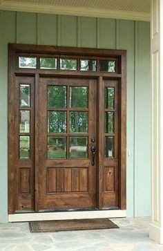 a wooden front door with glass panes