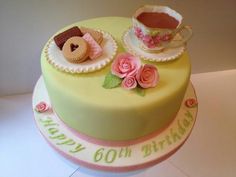 a birthday cake with tea and cookies on it