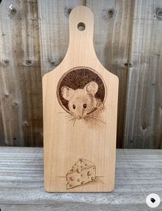 a wooden cutting board with an image of a mouse on it