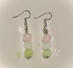 two pairs of earrings with pastel colors and silver earwires on a white surface