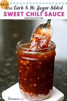 a glass jar filled with sweet chili sauce on top of a white plate next to a spoon