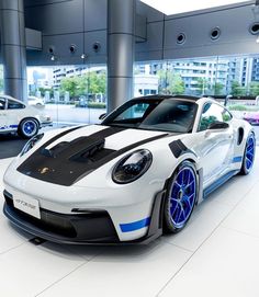 a white and blue sports car in a showroom