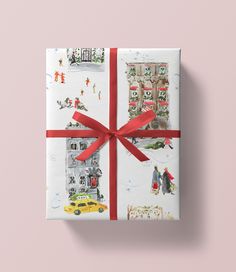 a present wrapped in white paper with red ribbon on top of pink background, featuring city scenes and people