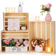 two wooden crates with flowers and candles in them, one has a bow on it