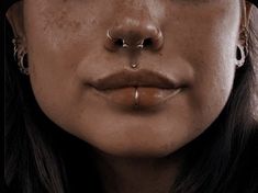 a woman with piercings on her nose and nose ring in front of her face