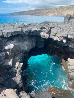 an ocean cave with blue water coming out of it's entrance into the sea