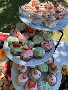 three tiered trays filled with cupcakes and muffins on top of each other