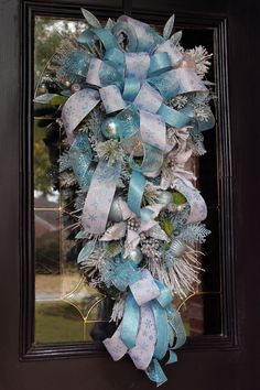 a blue and white wreath hanging on the front door