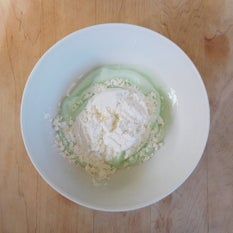 a white bowl filled with food on top of a wooden table