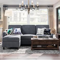 a living room filled with furniture and a chandelier hanging from the ceiling in front of a window