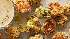 broccoli and cheese bites next to a cup of dipping sauce on a table