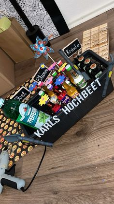 an assortment of beer and snacks in a box on the floor next to a toy mouse