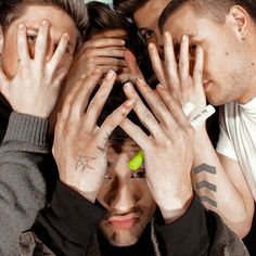 four young men are covering their eyes with their hands