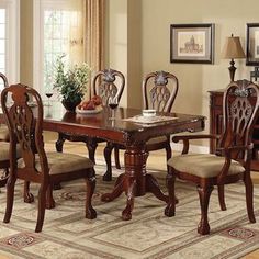 a dining room table and chairs with an area rug