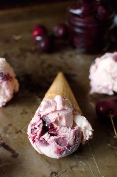 an ice cream cone filled with cherries on top of a table